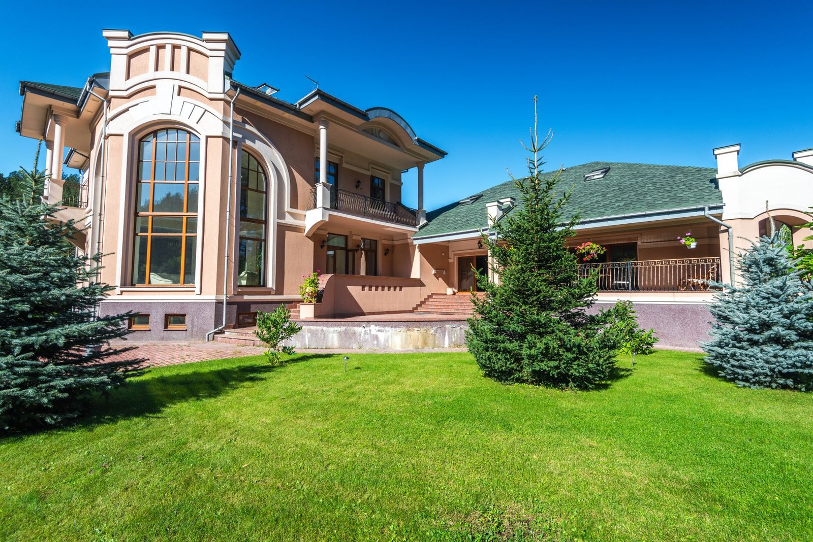 Large elegant villa seen from its landscaped front garden - illustrative stock photo