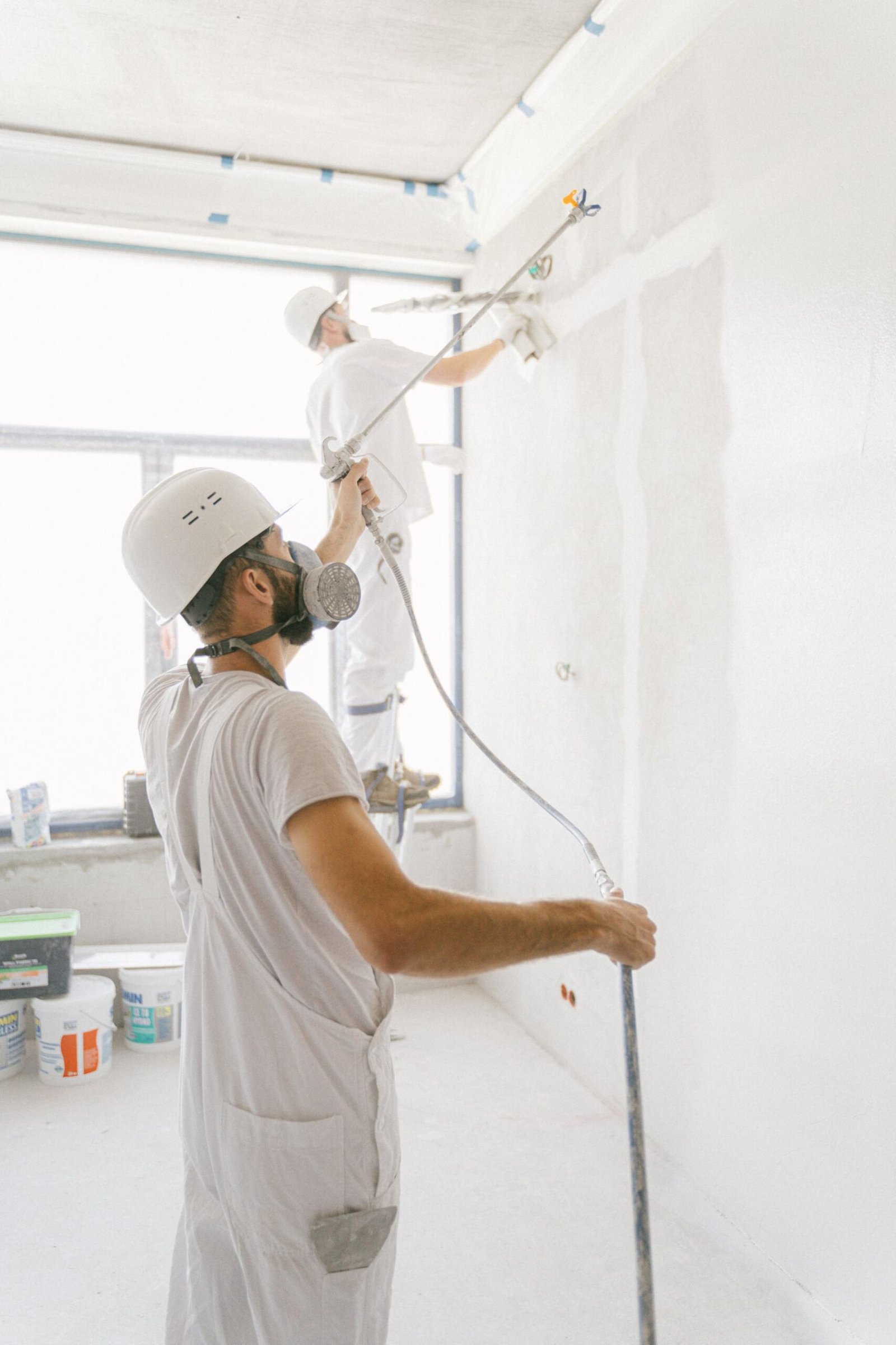 Two professional painters working on interior walls - illustrative stock photo