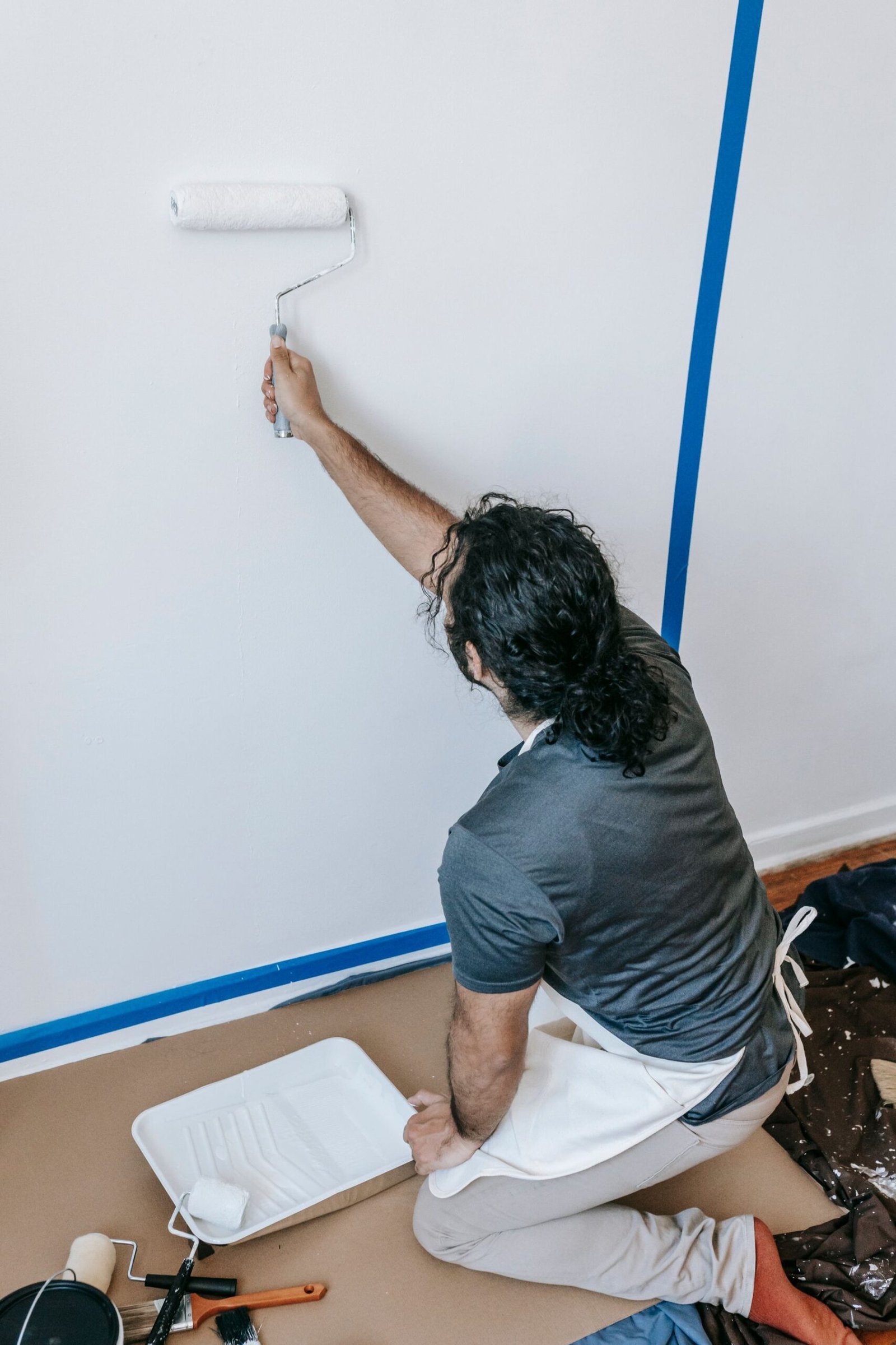 Painter applying a fresh finish to an interior wall - illustrative stock photo