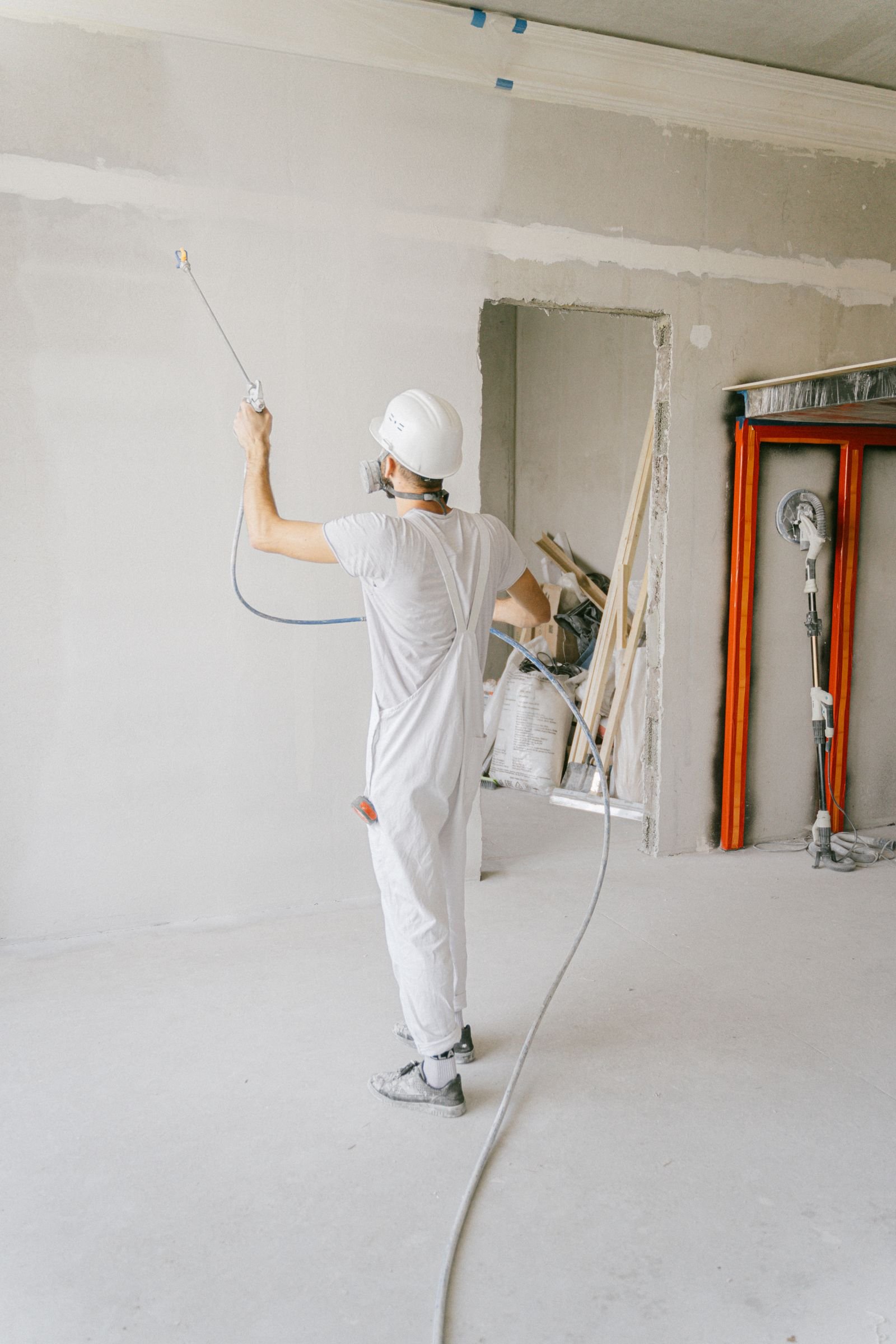 Professional worker applying primer during interior renovation - illustrative stock photo