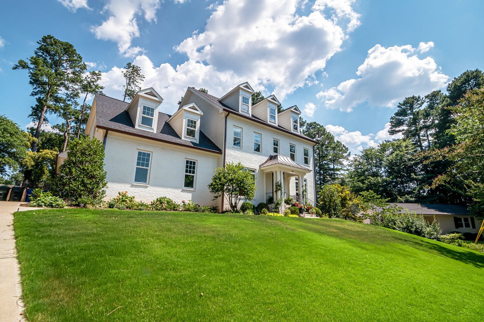 Spacious American home with a landscaped lawn under a blue sky - illustrative stock photo
