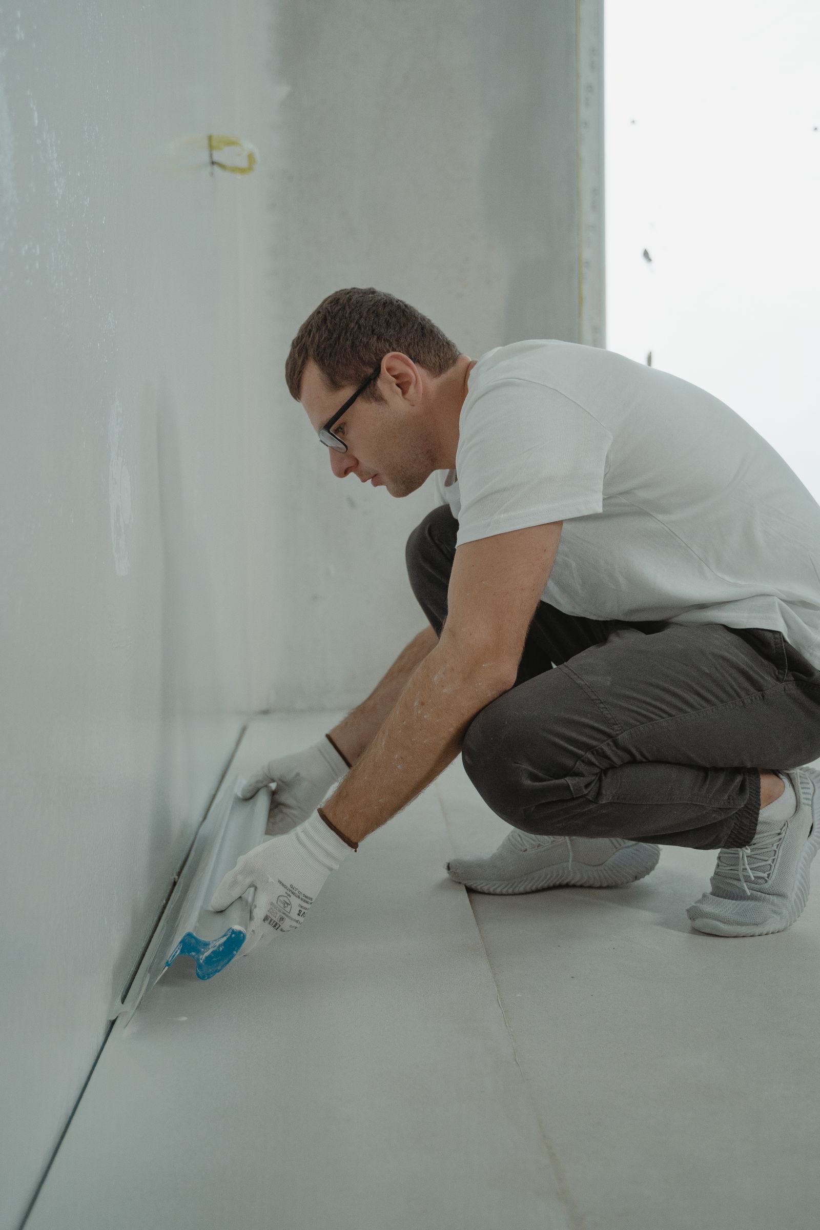 Worker carrying out interior surface renovation - illustrative stock photo