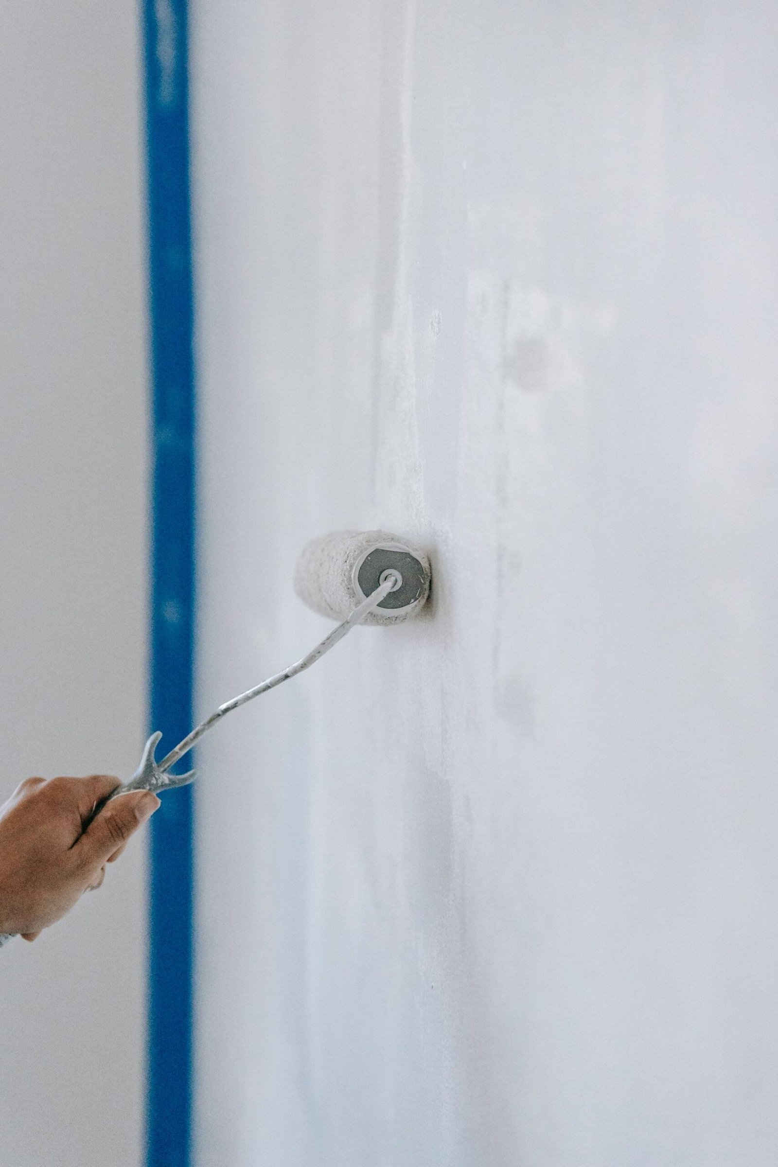 Applying fresh white paint with a roller - illustrative stock photo