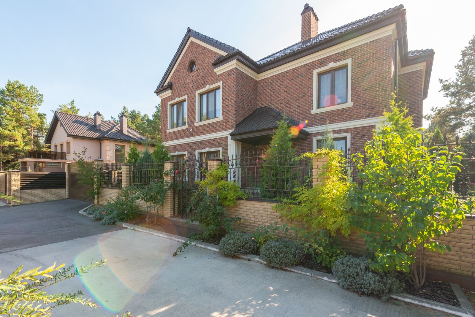 Brick house exterior with a garden and driveway - illustrative stock photo