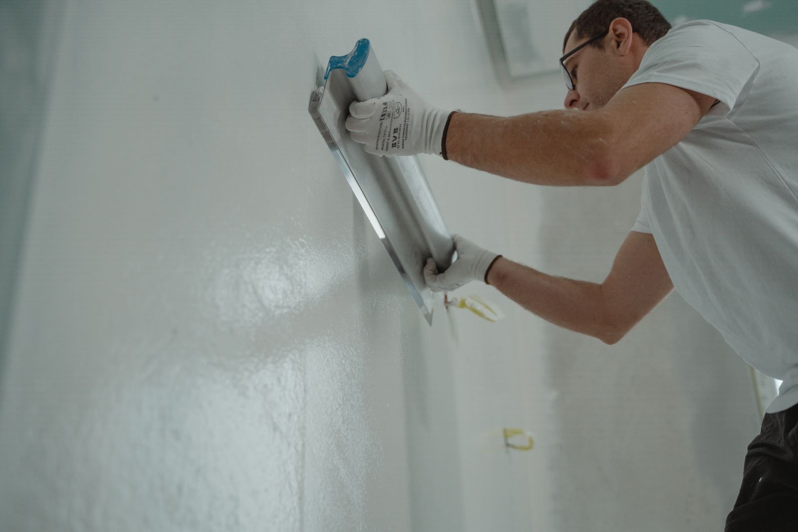 Worker applying plaster to an interior wall - illustrative stock photo