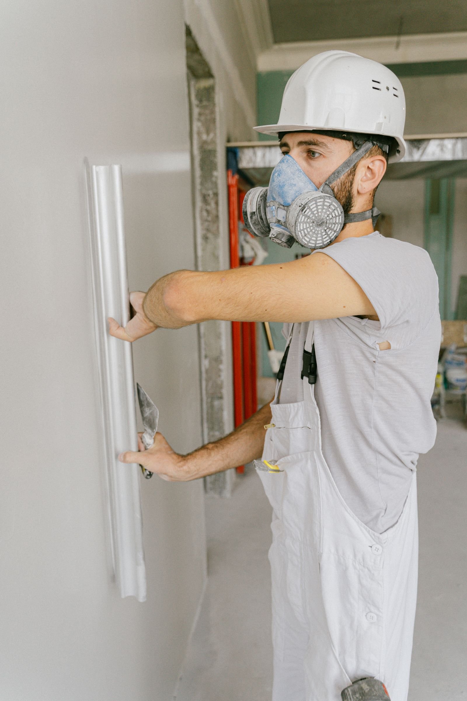 Worker smoothing an interior wall with a trowel - illustrative stock photo