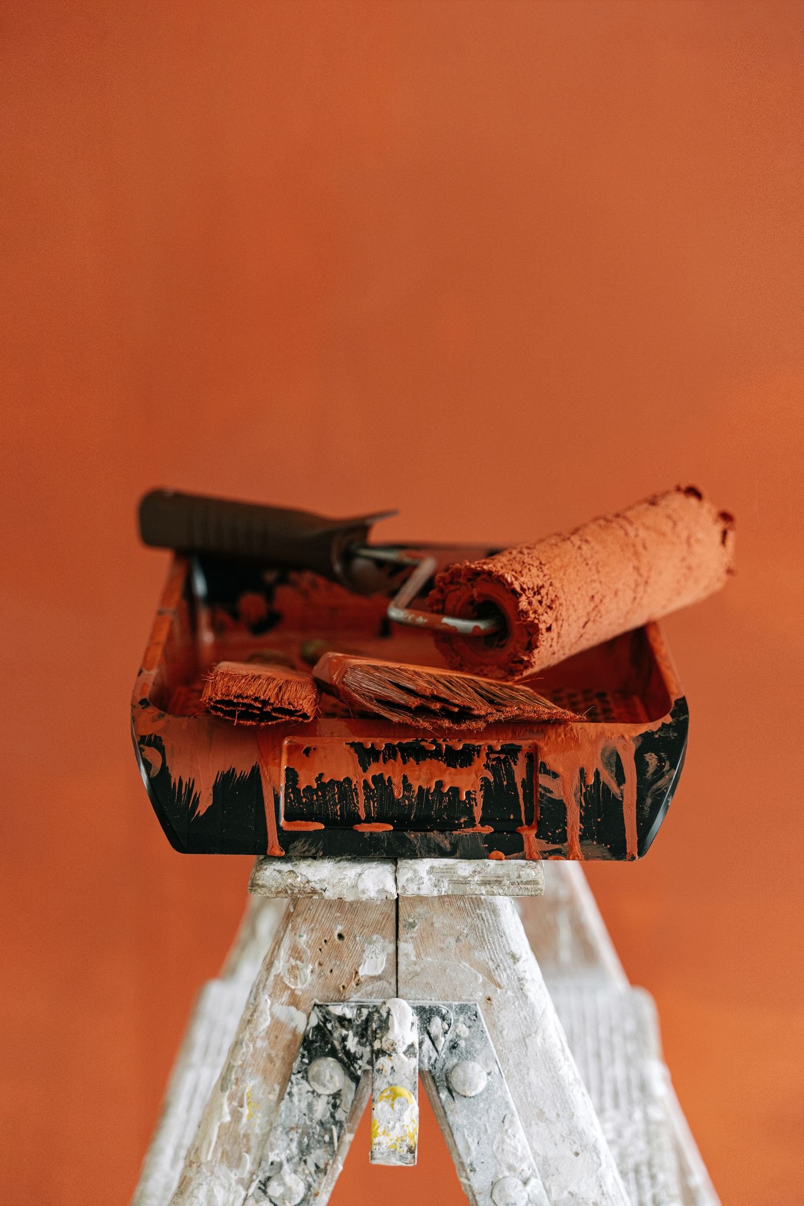 Paint tray, brushes and roller prepared on a stepladder - illustrative stock photo