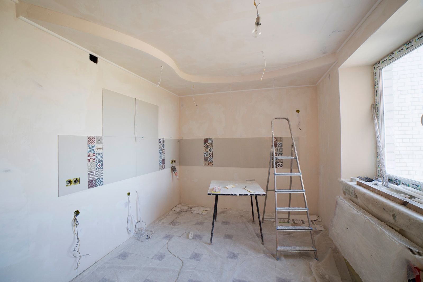 Kitchen interior undergoing renovation with a ladder and tools - illustrative stock photo