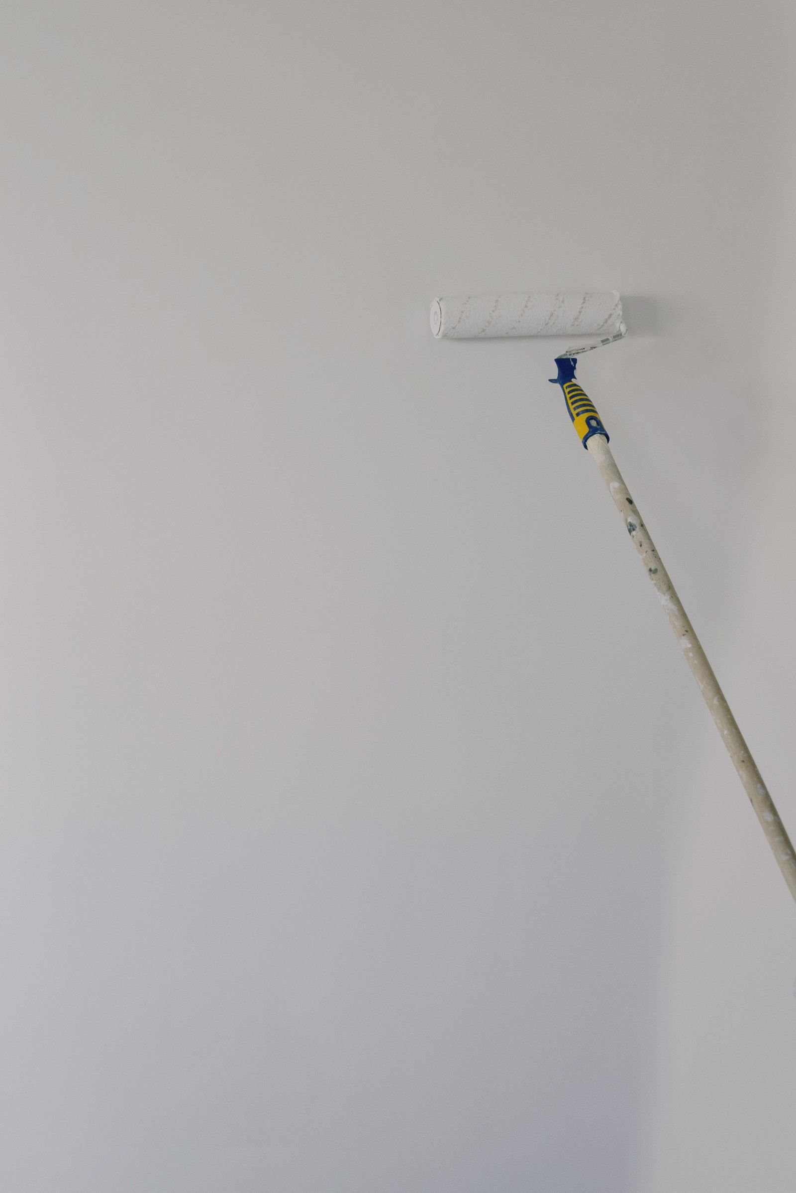 White paint being applied to an interior wall with a roller - illustrative stock photo
