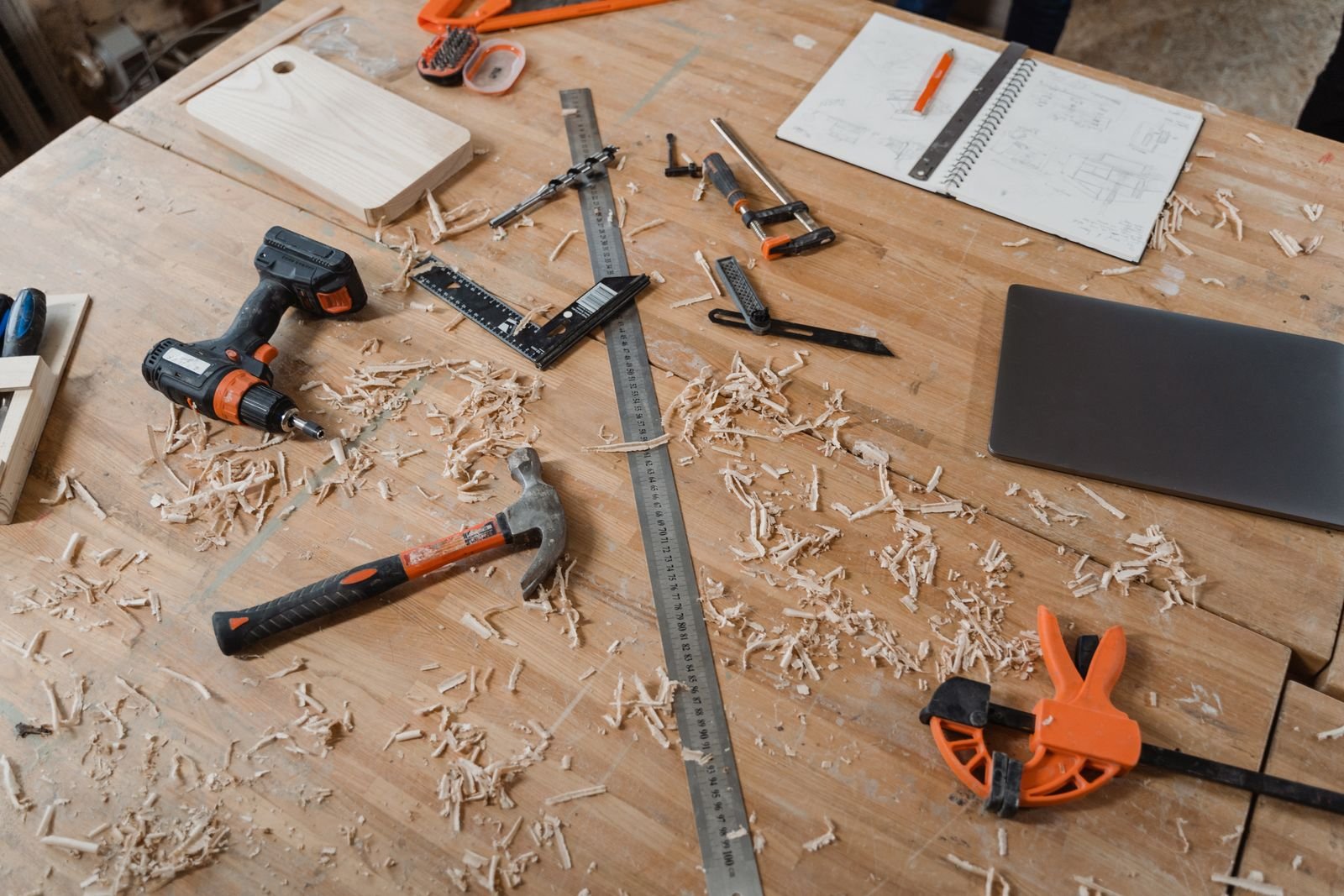 Carpentry tools, plans and wood shavings on a workbench - illustrative stock photo