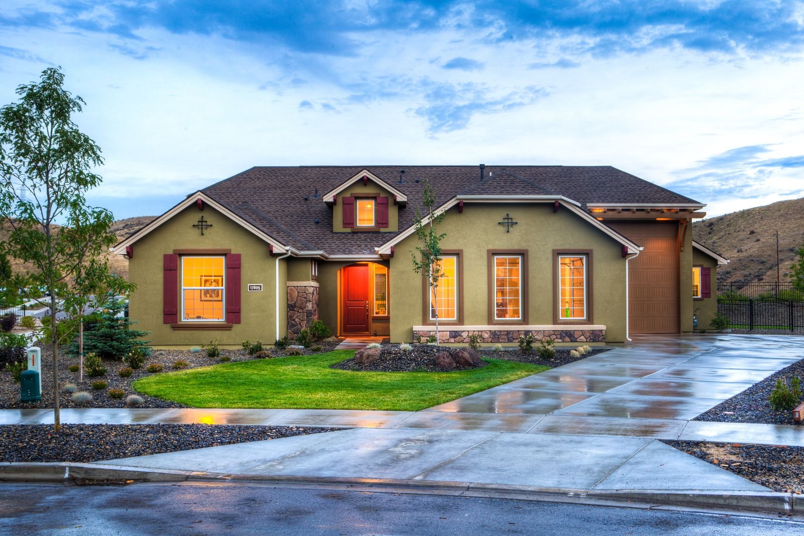 Modern detached house with illuminated windows at dusk - illustrative stock photo