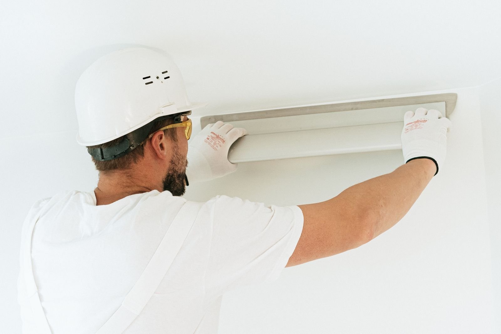 Construction worker carrying out work in a modern interior - illustrative stock photo