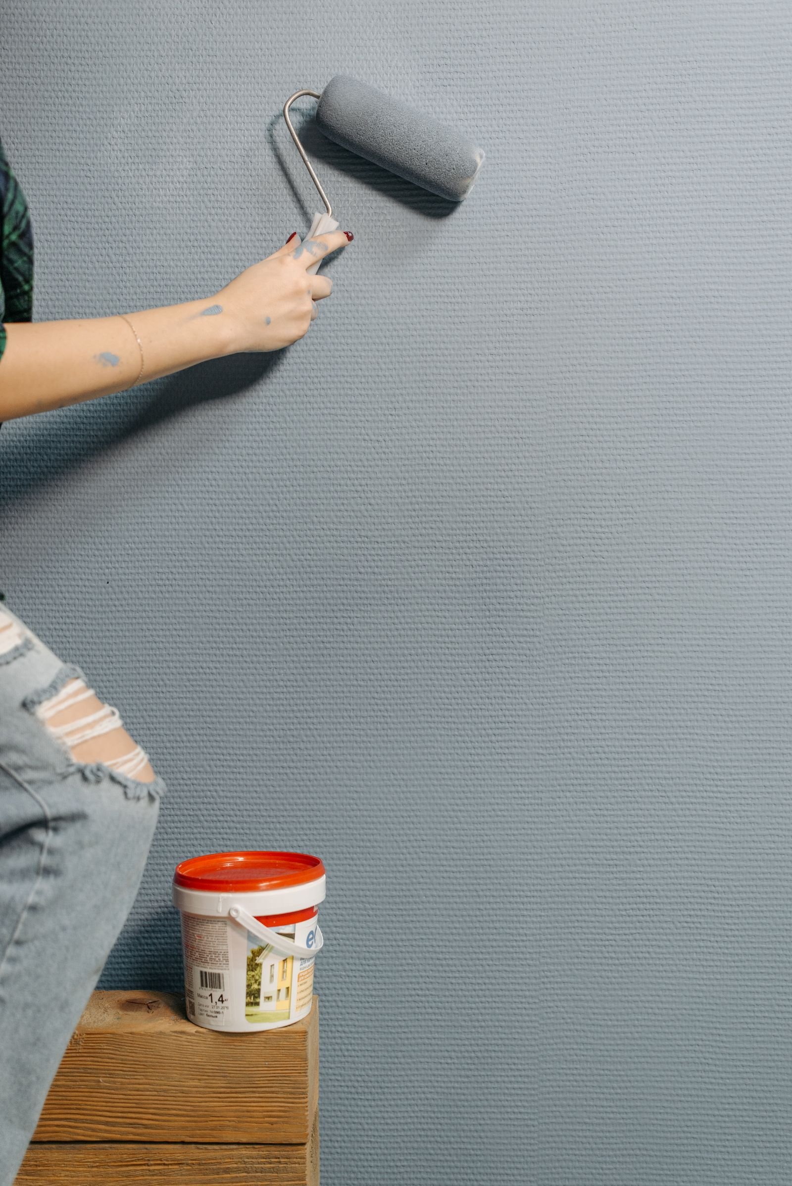 Painter applying color to an interior wall with a roller - illustrative stock photo
