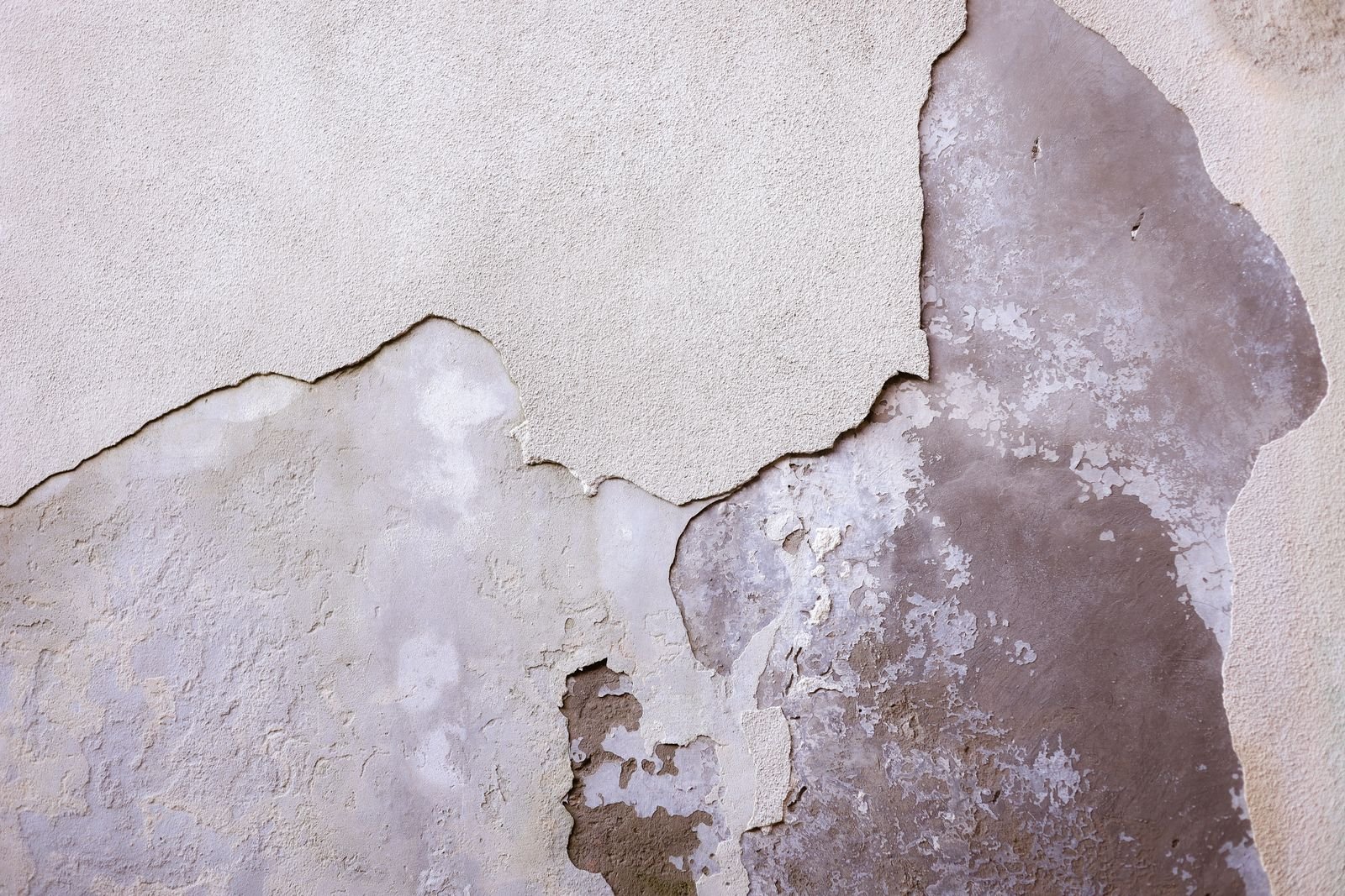 Close-up of a cracked and weathered wall surface - illustrative stock photo