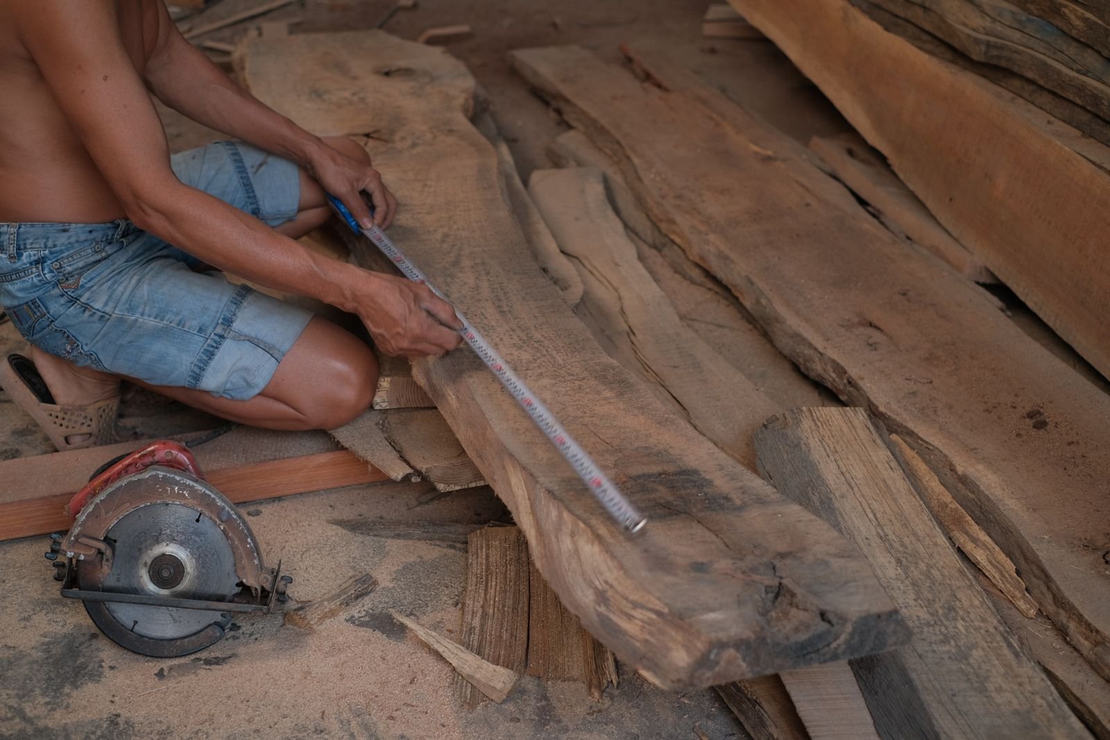 Carpenter measuring a wooden plank - illustrative stock photo