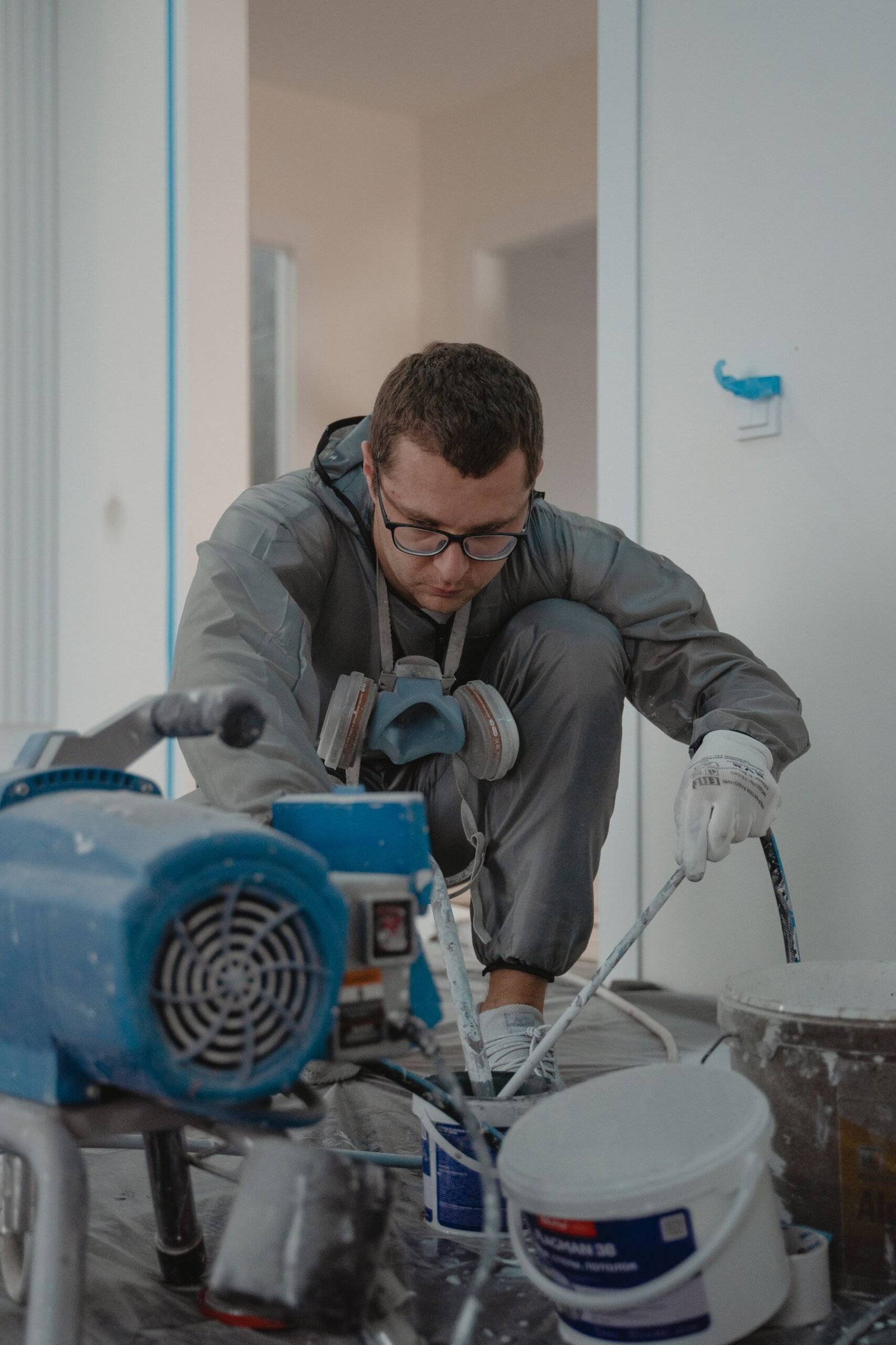 Professional painter in protective workwear applying an interior finish - illustrative stock photo